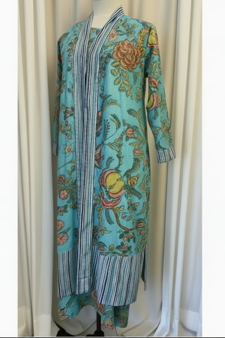 Colorful floral-patterned dress on a mannequin against a white curtain background