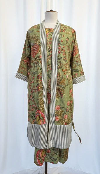 Mannequin wearing a floral dress with a long green cardigan in a store setting.